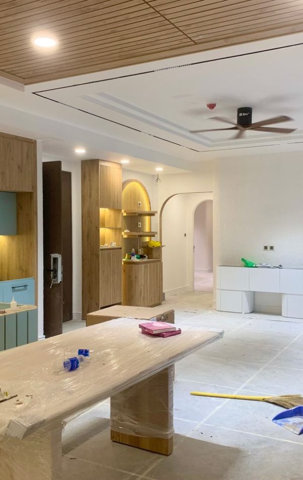 Spacious modern kitchen and dining area under renovation with wooden cupboards and stylish design.