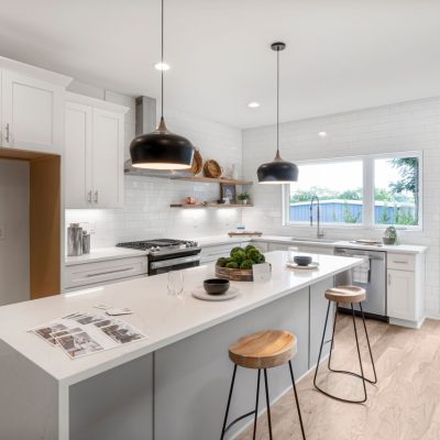 Home Bright modern kitchen with white cabinetry, wooden stools, and pendant lighting.